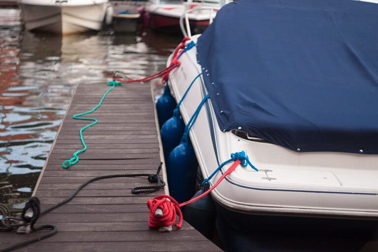 Boat at the jetty under a fitted navy cover