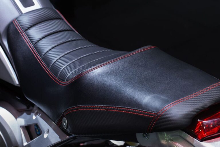 Black motorcycle seat re-covered with red stitching